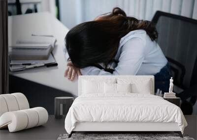 Alone Working Late. Asian business woman at workplace in office  laid her head down on the table fell asleep in front of laptop Wall mural